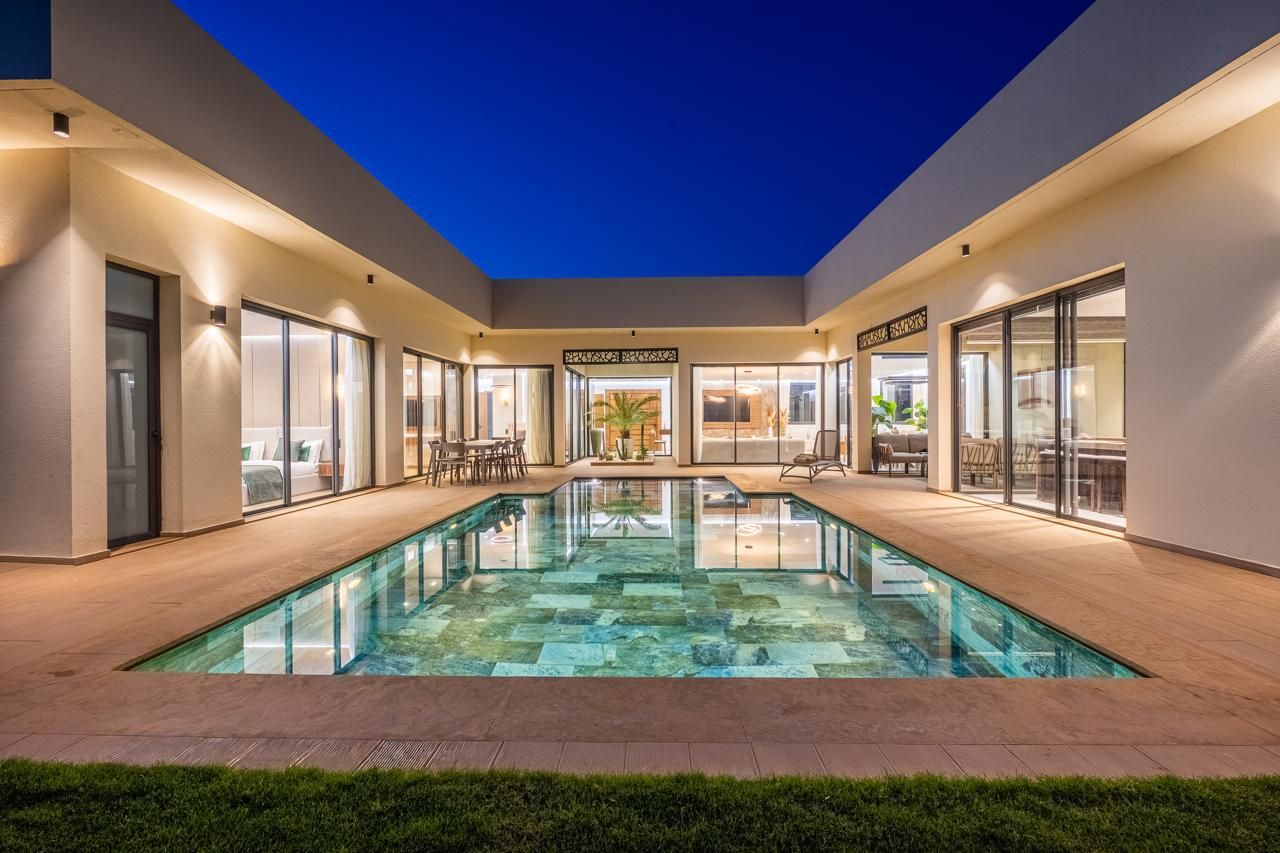La piscine chauffée illuminée de nuit, au cœur de la villa